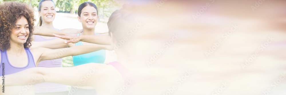 Women exercising with instructor at park