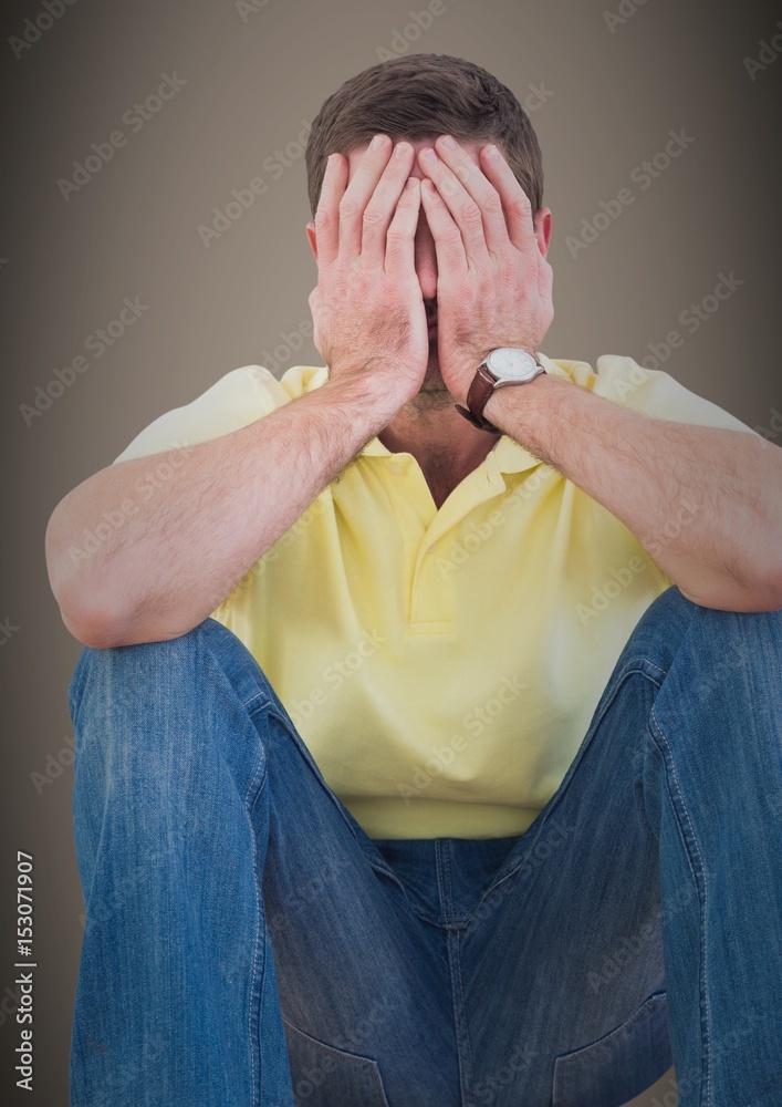 Man sitting with hands on face 