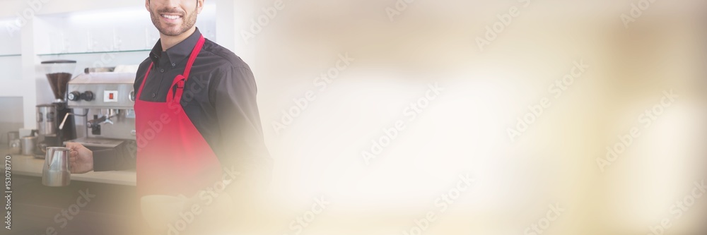 Handsome barista holding jug and cup