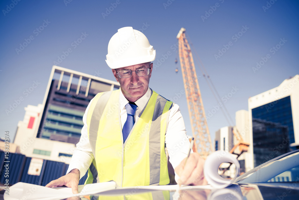 Senior foreman in glasses doing his job at building area on car 