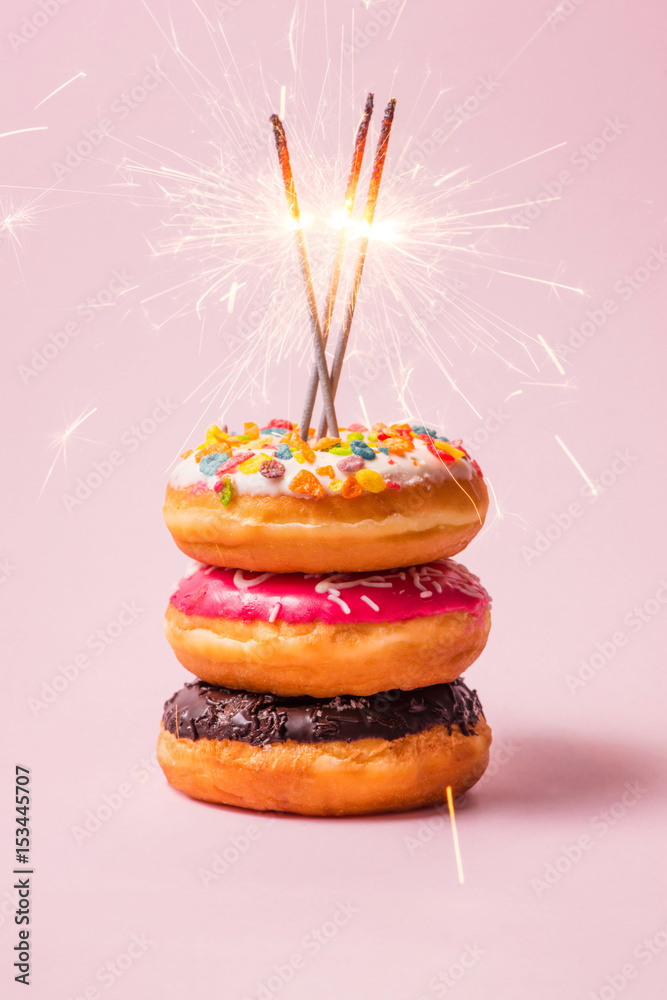 Delicious donuts for birthday on pastel pink background.