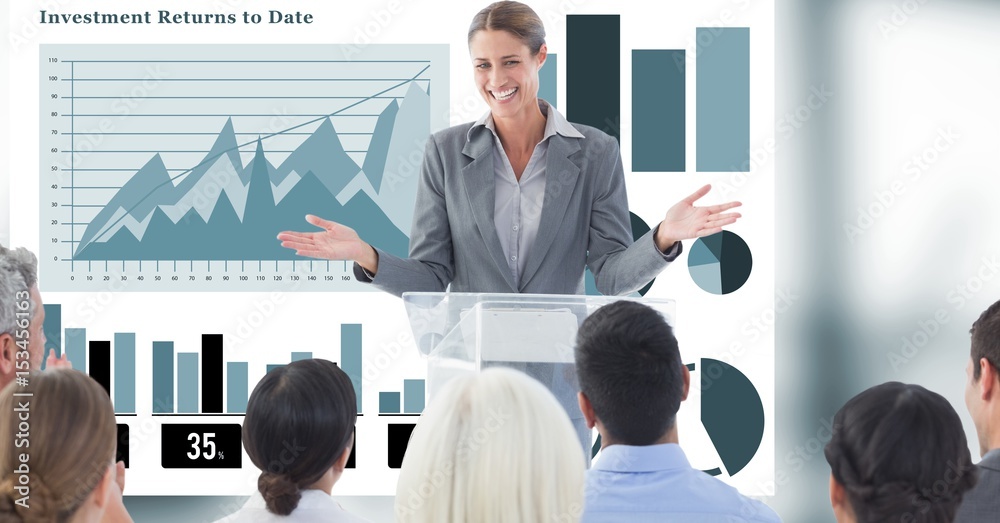 Businesswoman giving presentation to colleagues with graphs in background