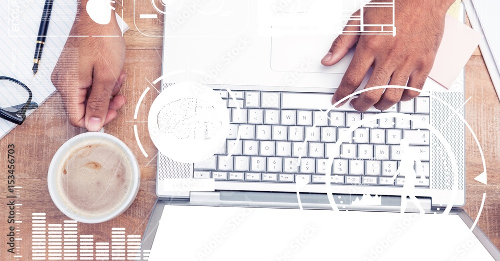 Hand using laptop while holding coffee cup