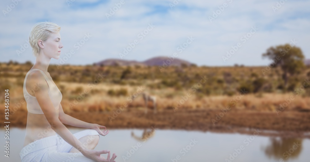 Double exposure of woman meditating by lake