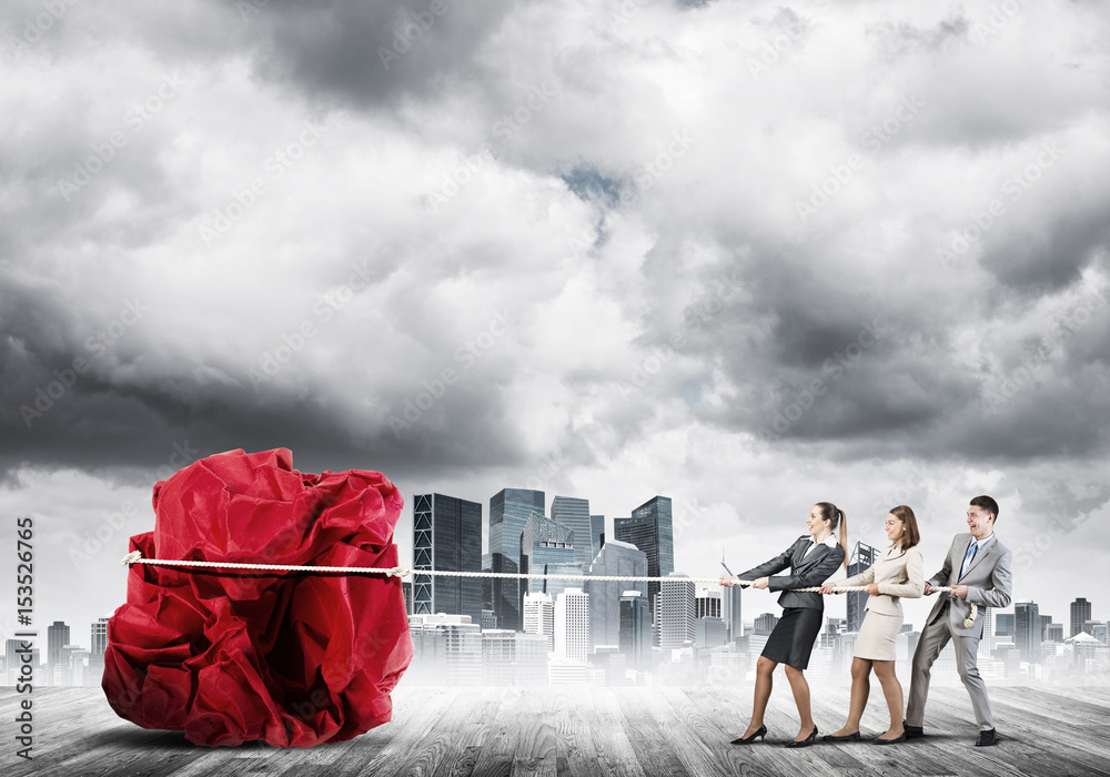 Young business people outdoors and huge paper ball as symbol of creativity