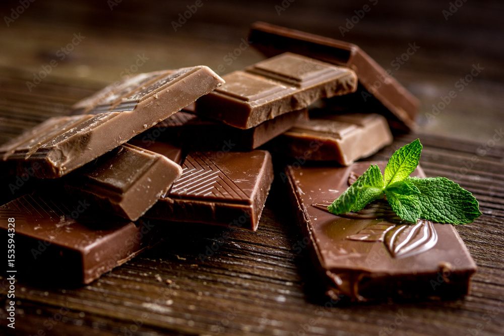 black chocolate design with mint on wooden background