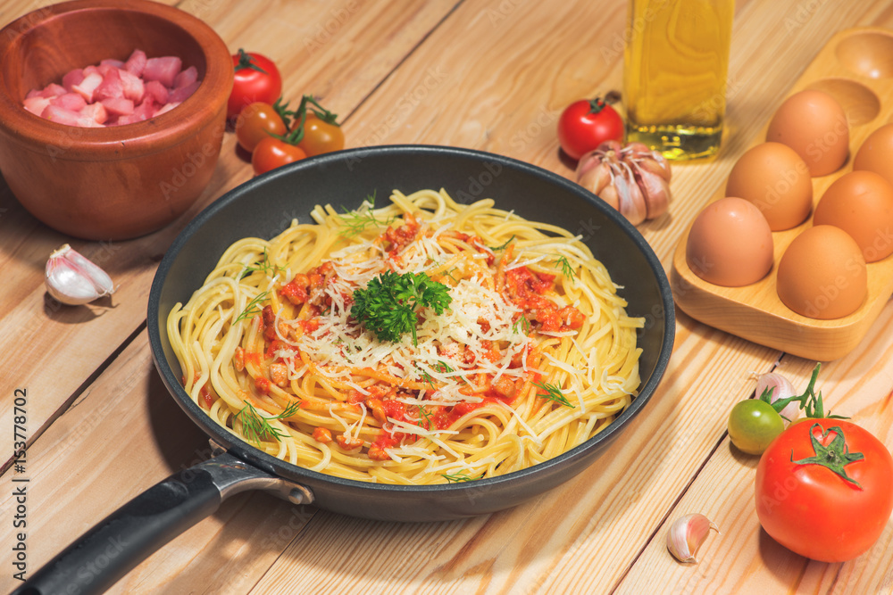 Tasty spaghetti with tomato sauce and meat in pan on wooden table.