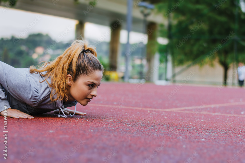 Fitness woman doing push-ups during outdoor cross training workout