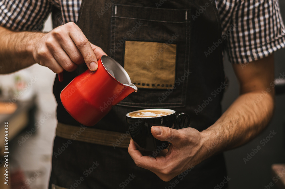 The bartender at the workplace. Male bartender makes cappuccino.