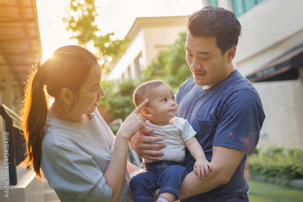 快乐的亚洲宝宝，妈妈和爸爸一起在公园里玩耍