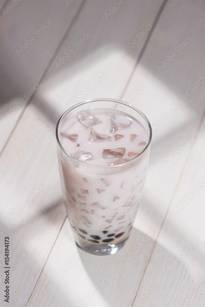 Boba / Bubble tea. Homemade Taro Milk Tea with Pearls on wooden table.