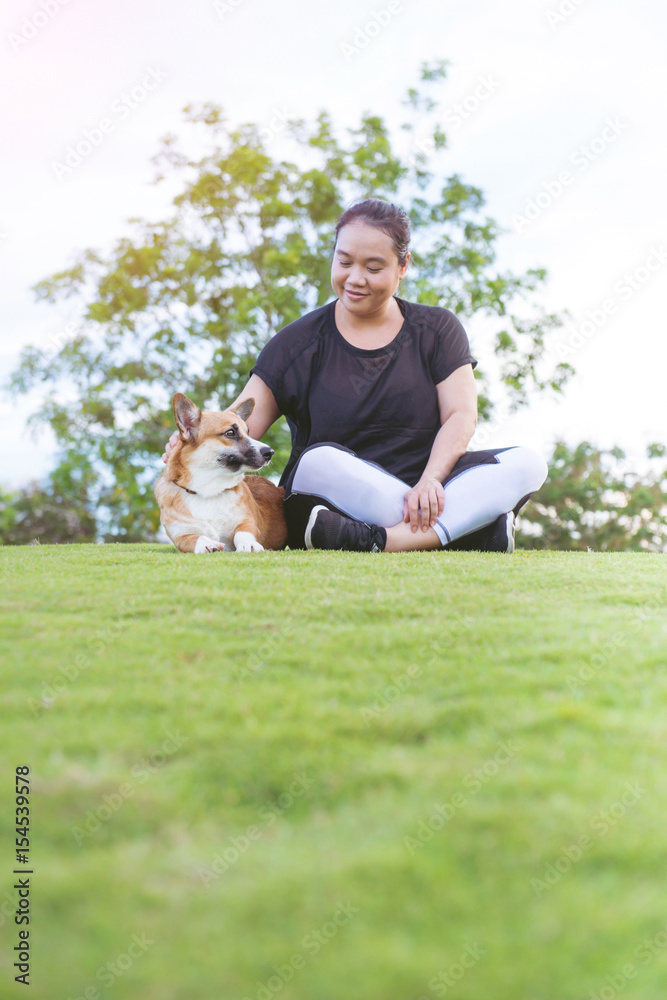 快乐的柯基犬与主人女孩在绿草上