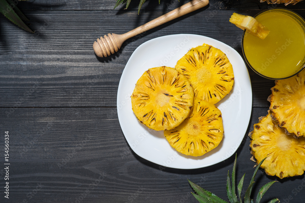 Grilled pineapple on a black wooden table