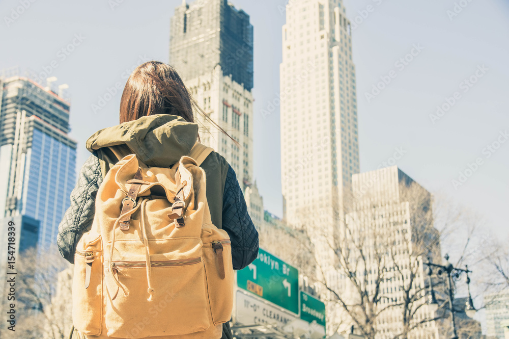 一位年轻旅行者背着背包刚抵达纽约的照片