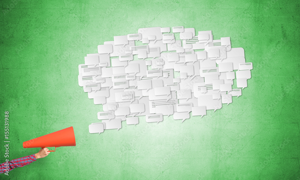 Hand of woman holding red paper trumpet and speech cloud