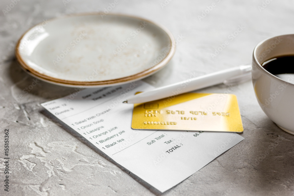 paying check for lunch in cafe with credit card on stone table background