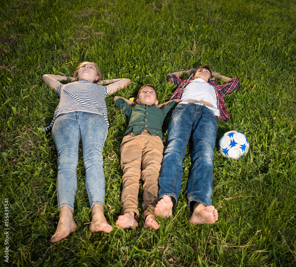 Group of happy kids lying on the grass