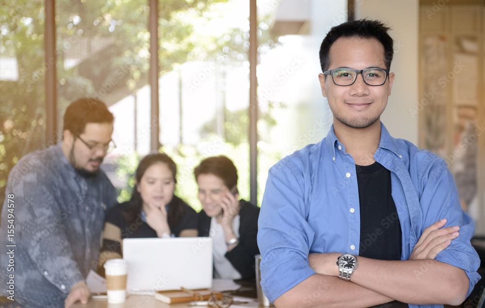 Young businessman smiling at camera in office