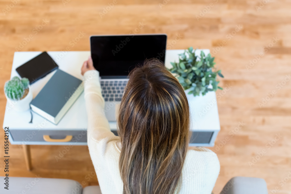 Happy young latina woman using her laptop at home