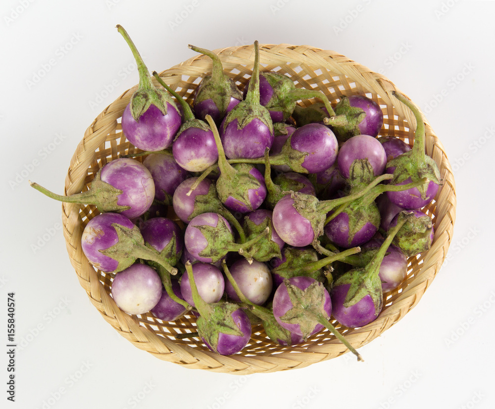 Pearl eggplant in a bamboo basket isolated on white background
