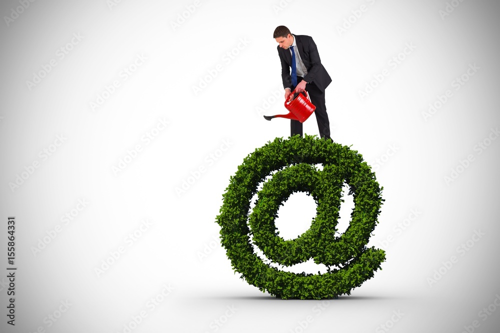 Composite image of businessman holding red watering can