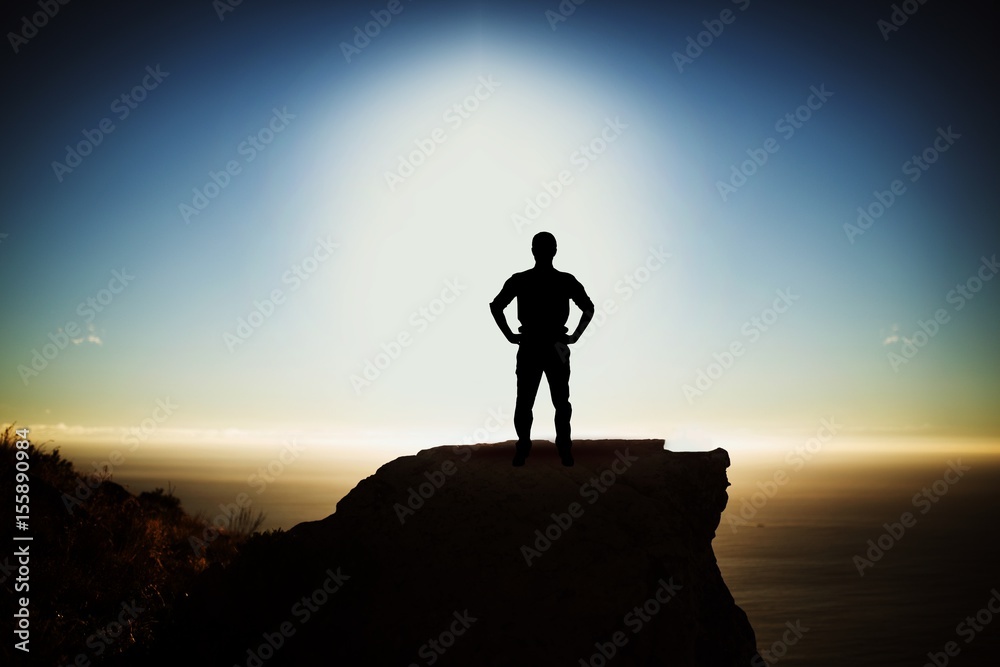 Composite image of businessman standing with hands on hips