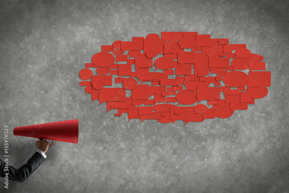 Hand of businesswoman holding red paper trumpet and speech cloud