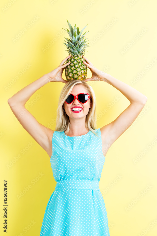 Happy young woman holding a pineapple