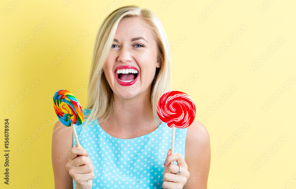 Young woman holding lollipops