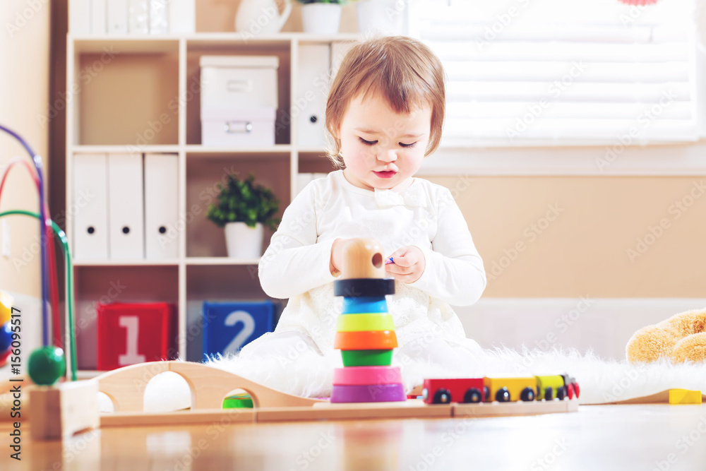 Happy toddler girl playing with toys