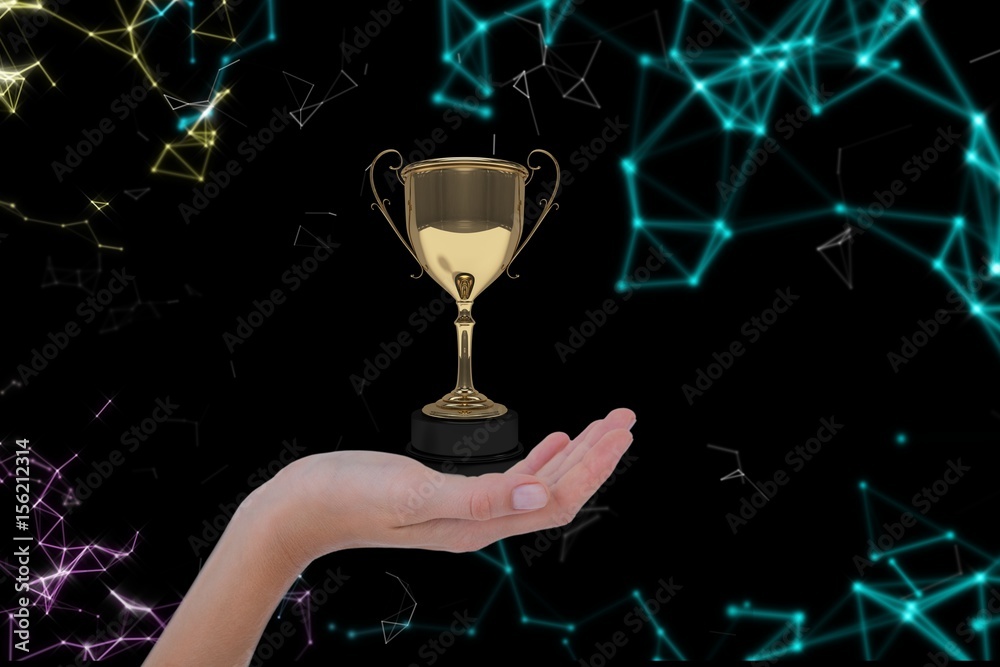 Hand holding a trophy against atomic structure background 