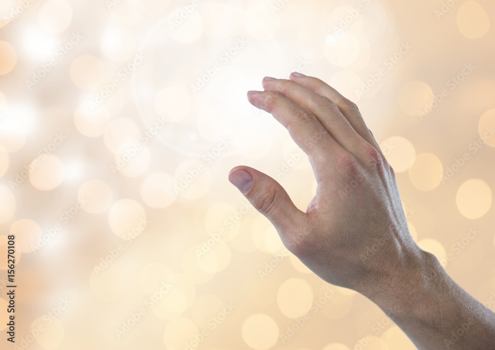 Hand touching brightness with sparkling light bokeh background