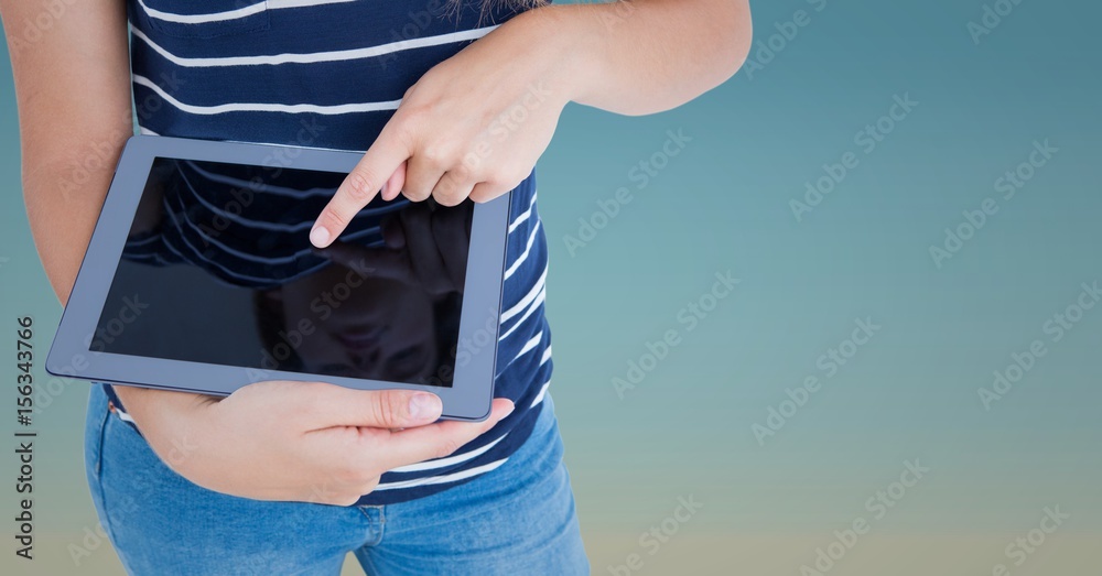 Woman mid section with tablet against blue gradient