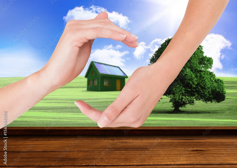 grass house with panels between hands in the field