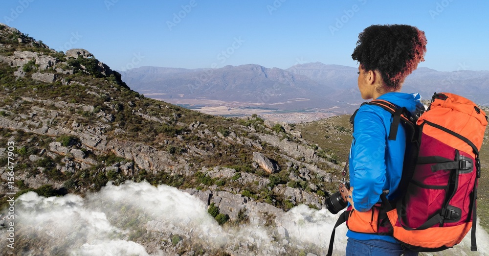 嬉皮士站在悬崖上看山，背靠天空