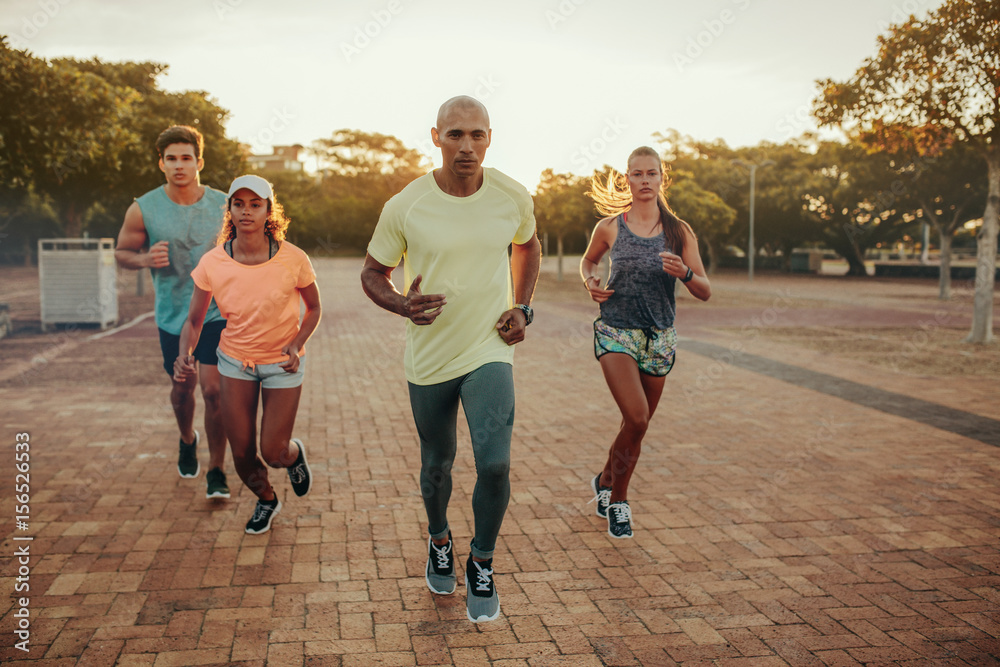 Fit young man runs with friends