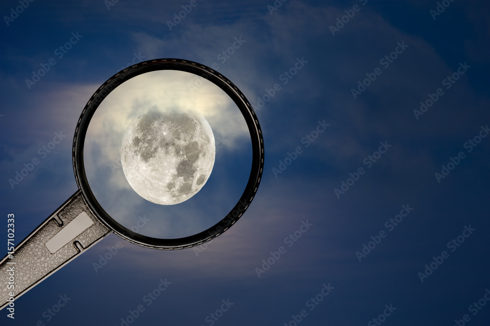 Full moon and cloudy sky with magnifying glass