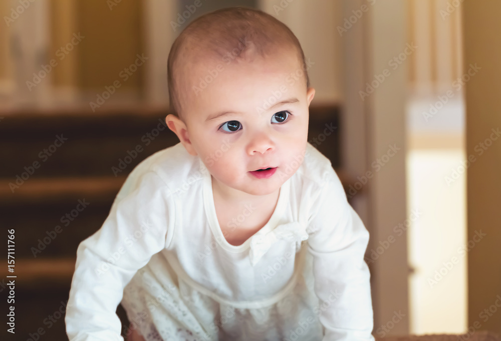 Happy toddler girl climbing the stairs in her house