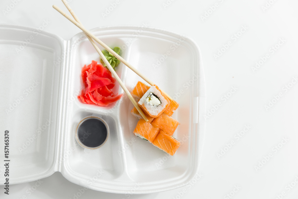 roll with chopsticks, rolls, sushi. container delivery sushi and chopsticks.