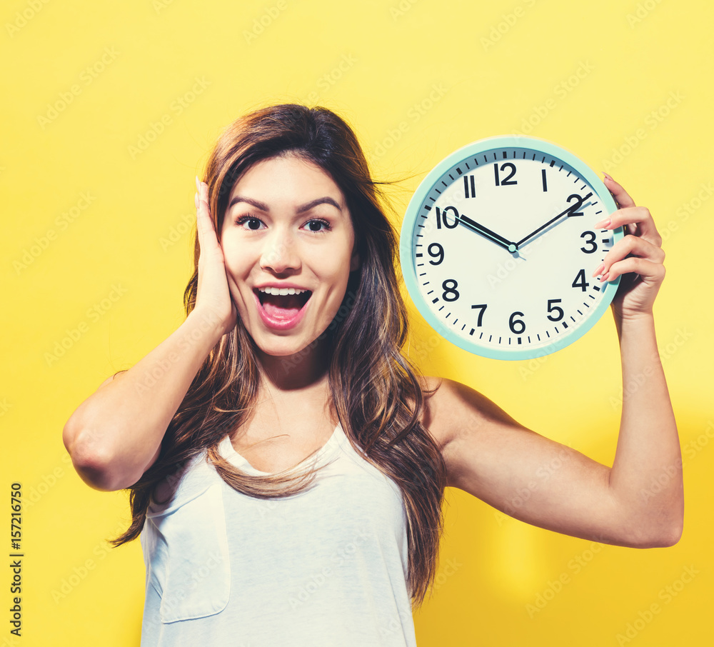 Young woman holding a clock