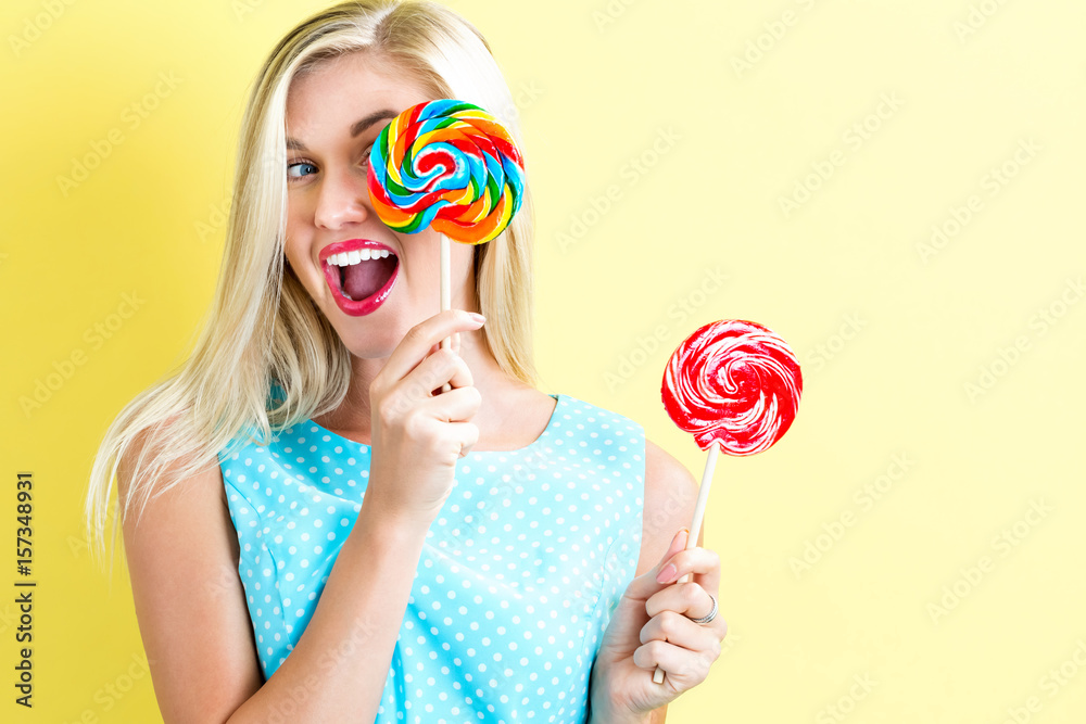 Young woman holding lollipops