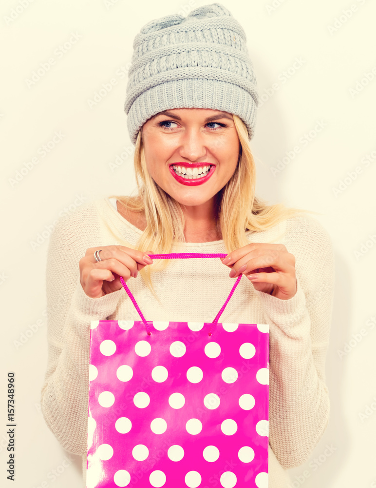 Happy young woman holding a shopping bag