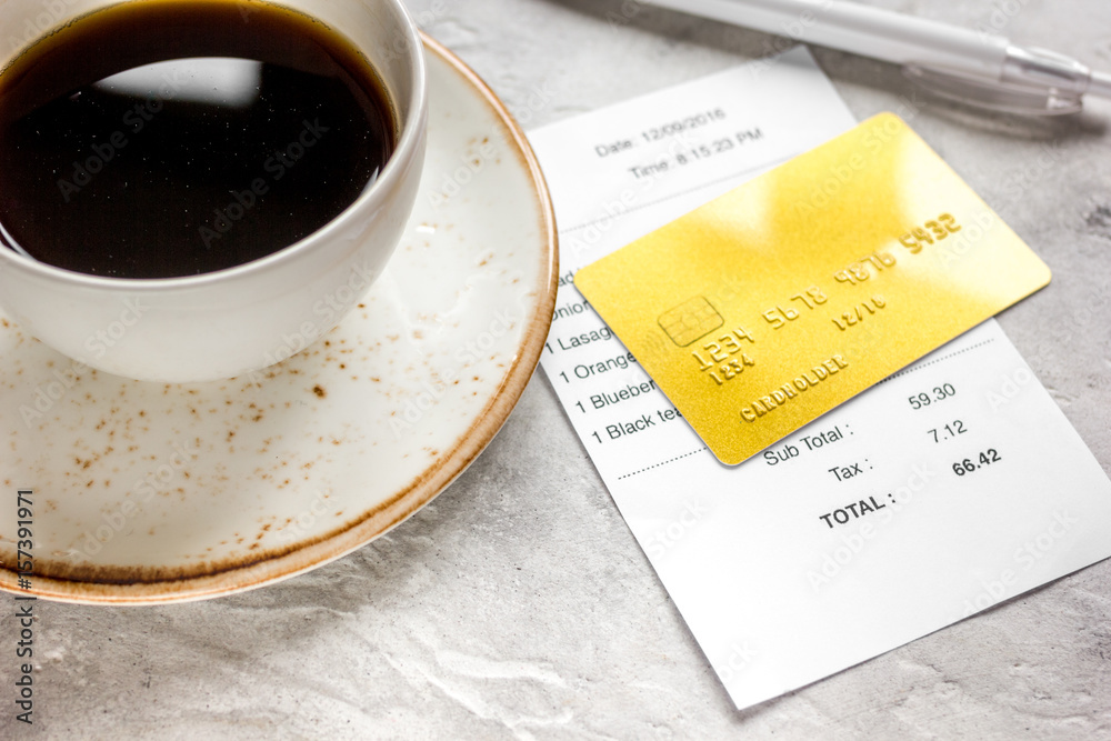 paying check for lunch in cafe with credit card on stone table background