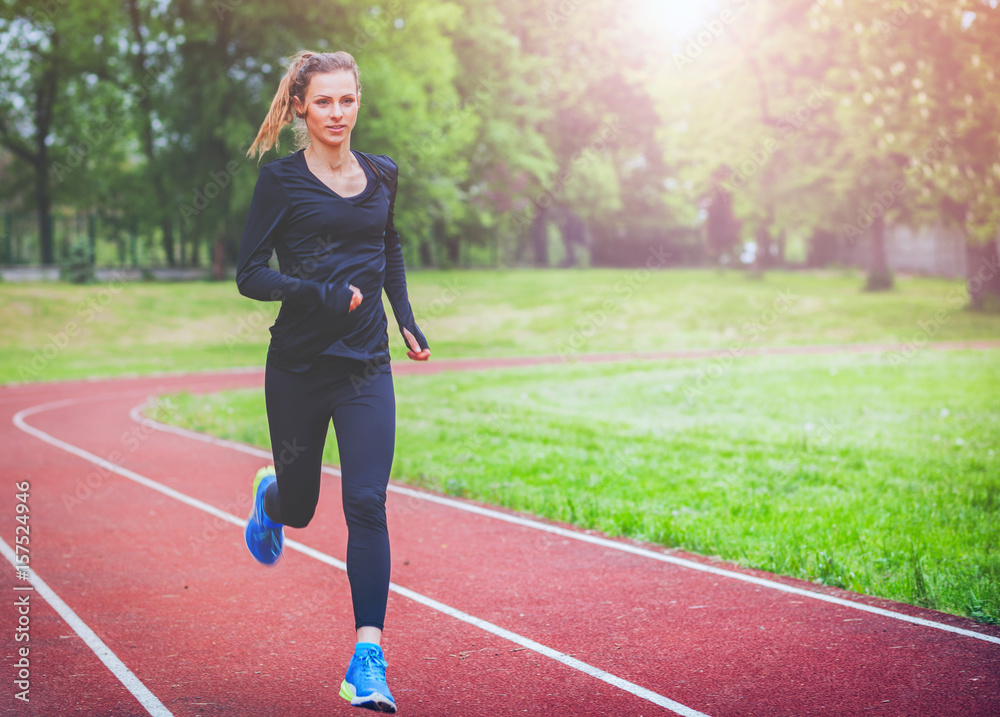 Athletic woman running on track, healthy lifestyle