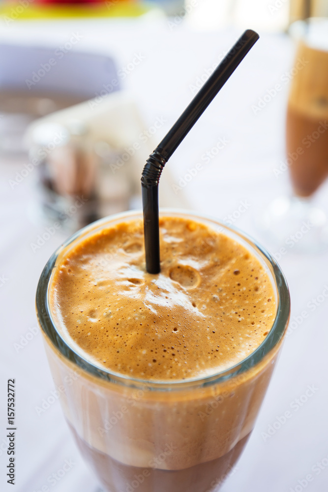 Glass of freppe - greek cold iced coffee on table