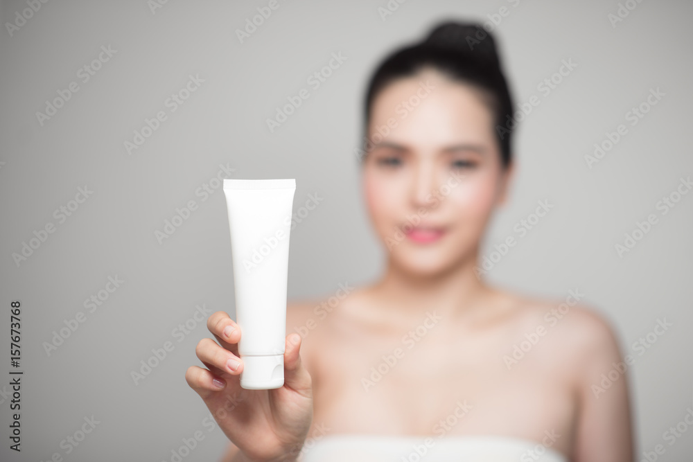 Beauty concept. Asian pretty woman with perfect skin holding cosmetic bottle