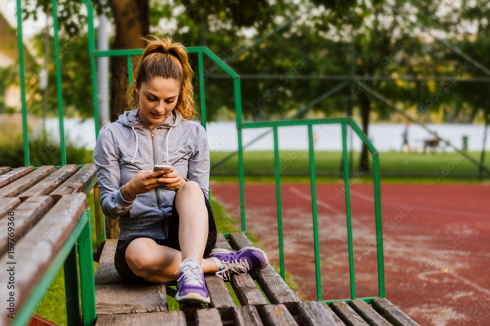 Portrait of an attractive young woman using a smartphone while sitting on a bench