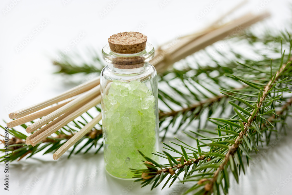 Spruce spa with organic salt in bottles on white table background