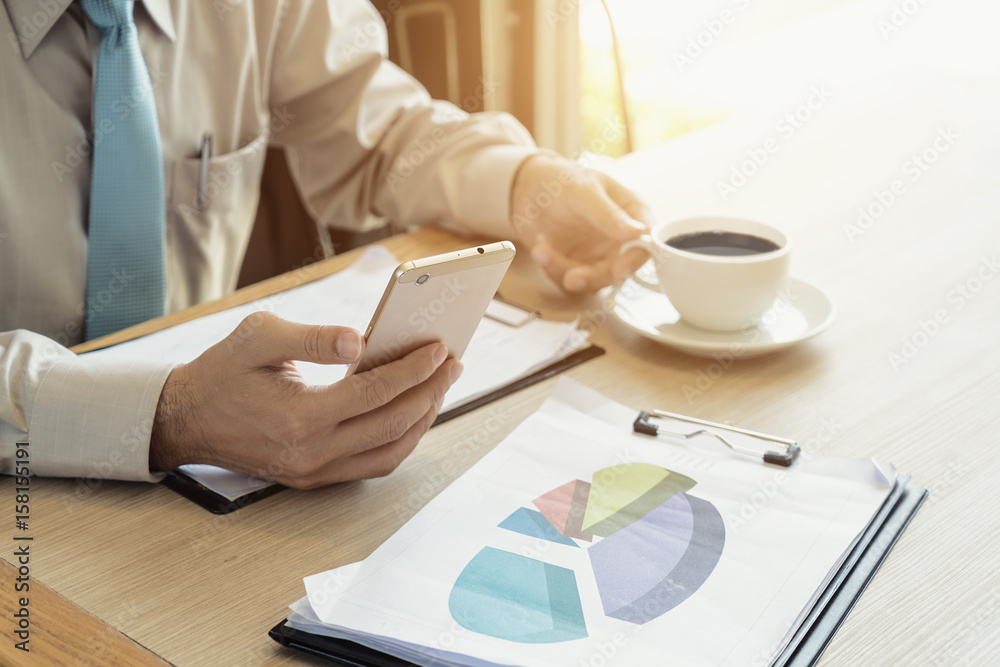 Businessman with a cup of coffee reading his smart phone in a cafe. Business, people, break concept.