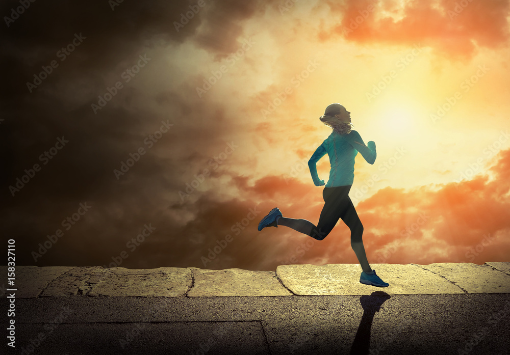 Woman running on the coastline under sunlight.